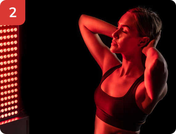 Woman sitting in front of a large red light panel