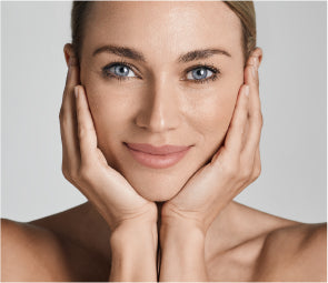 woman smiling with hands on face