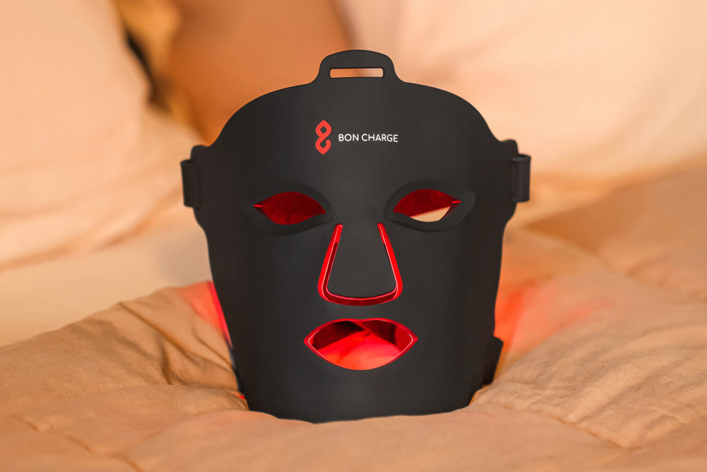 Bon Charge mask glowing red as it rests on a bed in a calm evening setting