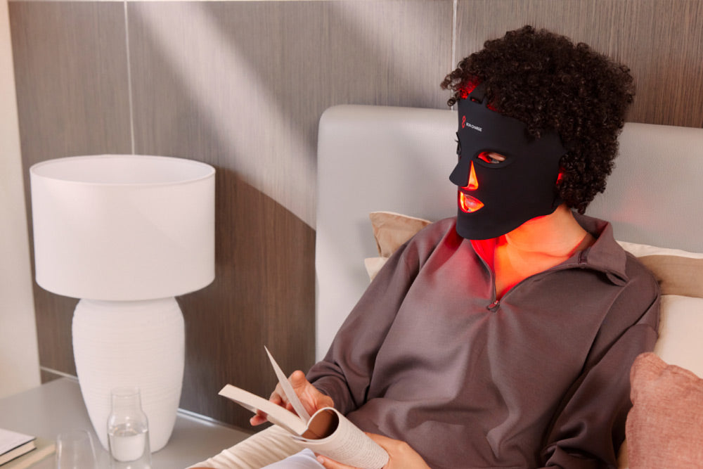 Person relaxing and reading in bed while wearing the cordless Bon Charge mask hands-free