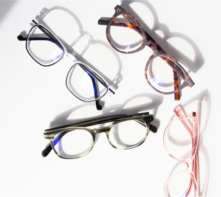 several pairs of clear lens computer glasses on table